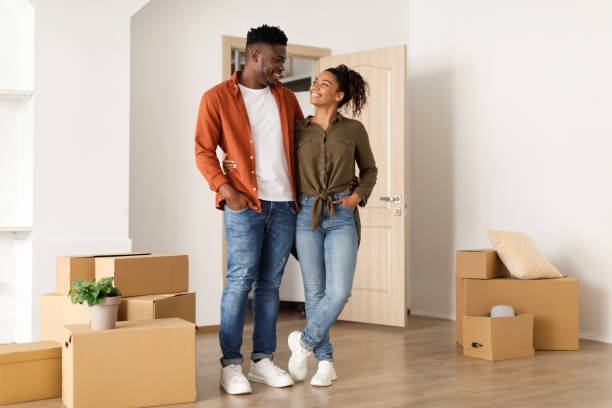 istock Joyful African Spouses Hugging Among Moving Boxes In New Home 1373303352