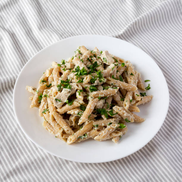 istock Homemade Chicken Alfredo Penne with Parsley on a white plate, side view. 1373304177