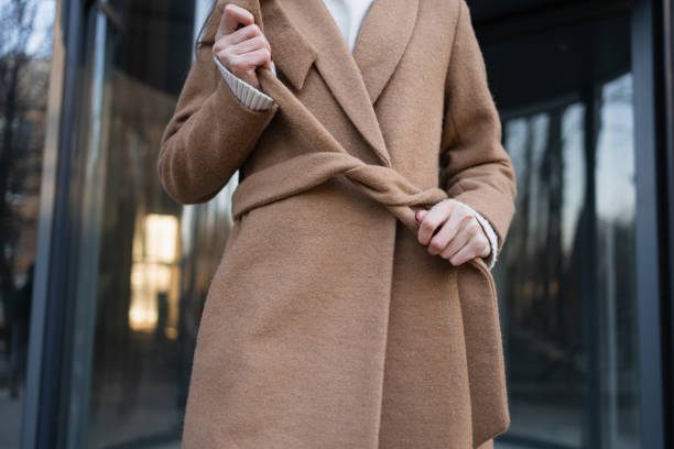istock Woman is tying a belt on a coat 1373304780