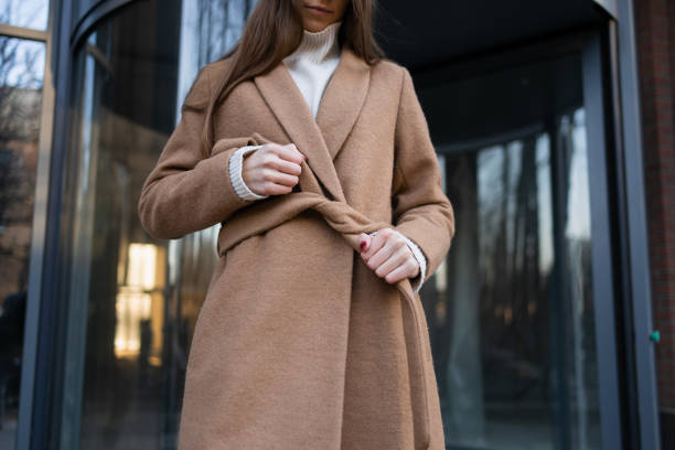 istock Girl is tying a belt on a coat 1373304803