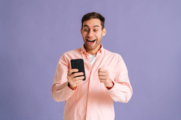 istock Portrait of surprised excited young man screaming during using mobile cell phone just found out great big win news, doing winner gesture say yes. 1373306497