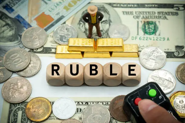 Photo of Falling rouble, economic crisis, impact of war.devaluation of the currency.international finance.commerce and banking.table covered with banknotes and gold, dice with the word.Press and hold the down button.