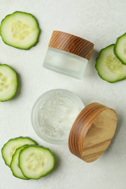 istock Jars with cosmetics and cucumber slices on white textured background 1373314403