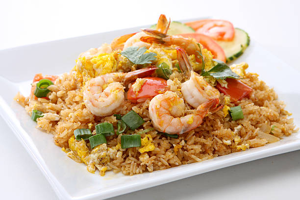 Thai Tom Yum Fried Rice or Prawn Biryani in isolated on backdrop. Tom Yum Fried Rice is Thailand cuisine dish with jasmine rice, shrimps and vegetables. Thai Food. Top view