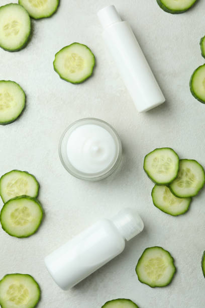 istock Cosmetics and cucumber slices on white textured background 1373318110
