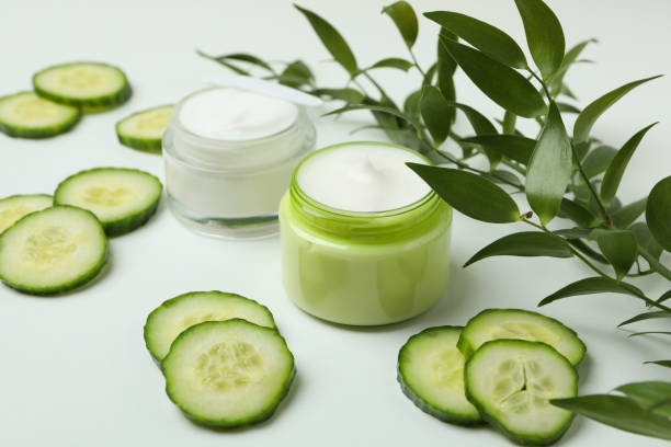 istock Jars with cosmetic cream, cucumber slices and branch on white table 1373318861