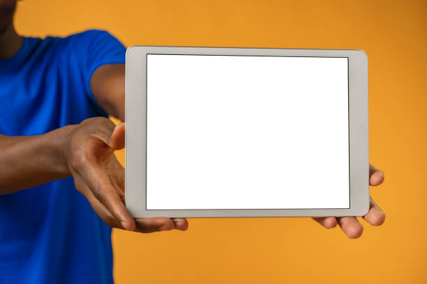 istock African man showing digital tablet over yellow background. 1373345449