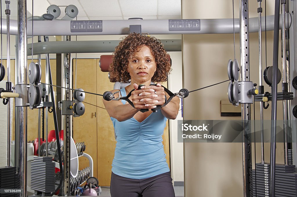 Stehende Frau macht Liegestütz in einem Fitnessstudio - Lizenzfrei Stahlkabel Stock-Foto