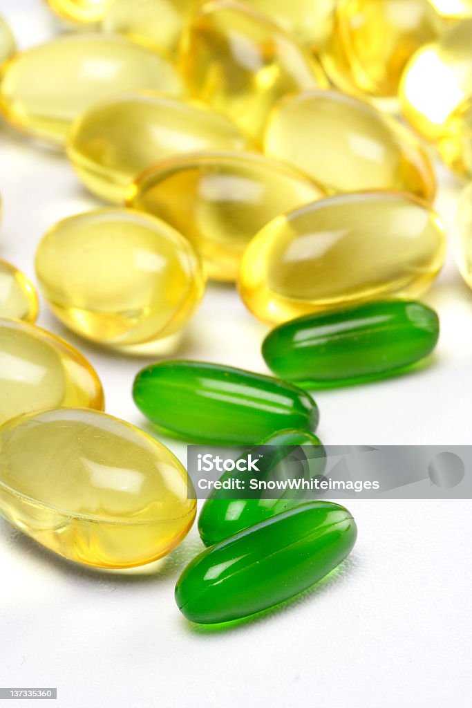 Jaune et vert vitamine capsules - Photo de Complément vitaminé libre de droits