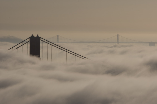 The golden gate bridge and the bay bridge in the morning fog.