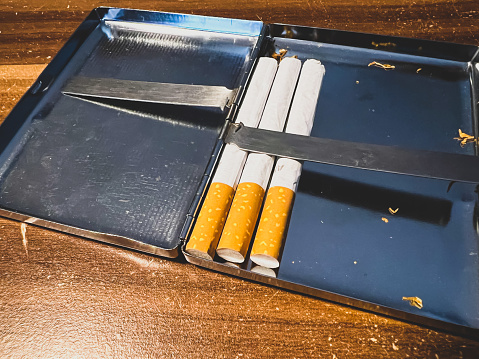 Homemade cigarettes in a shiny iron box.