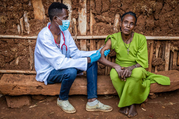 un médecin fait une injection à une femme africaine âgée dans un petit village, en afrique de l’est - developing countries photos et images de collection