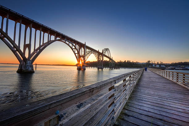 The fishing dock at Newport Oregon at Sunset with the arching bridge.
