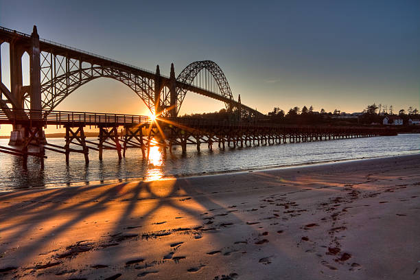 newport bay-brücke bei sonnenuntergang - newport oregon stock-fotos und bilder