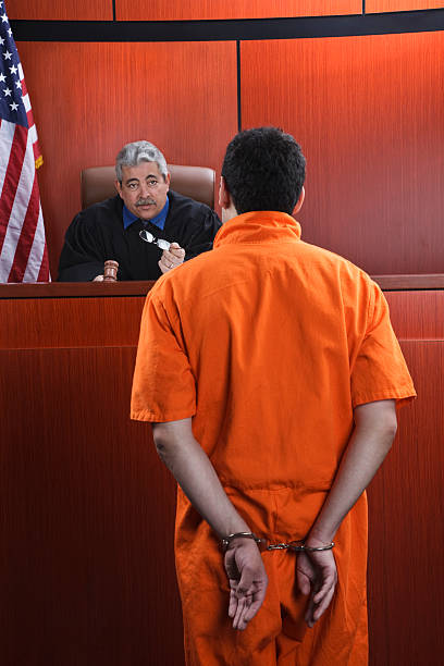 Judge Speaks to Prisoner in Courtroom stock photo