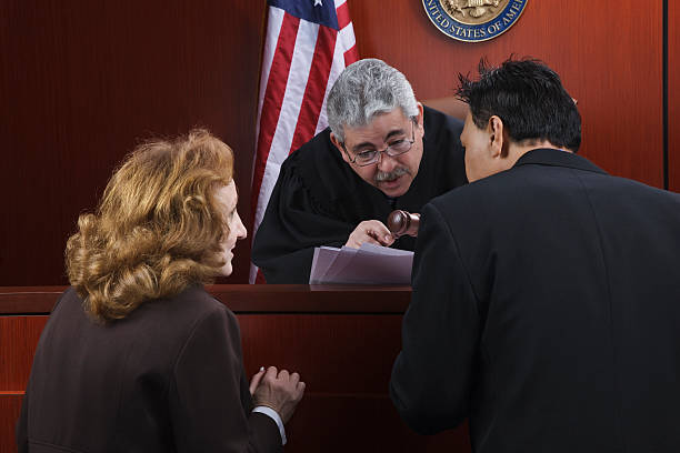 Two attorneys speaking with the judge in the courtroom stock photo