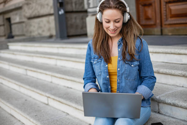 istock Young woman using laptop in front of the University 1373405819