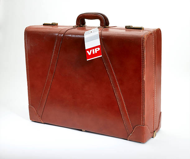 VIP Luggage A vintage leather suitcase with a VIP tag. priority baggage tag stock pictures, royalty-free photos & images
