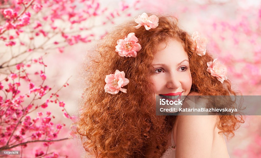 Spring Beautiful red hair girl in flowers. Adult Stock Photo