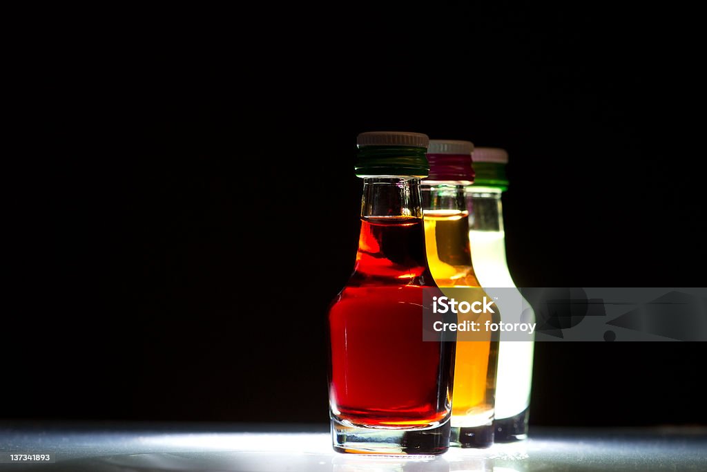 three little bottles three little bottles against a black background Alcohol - Drink Stock Photo