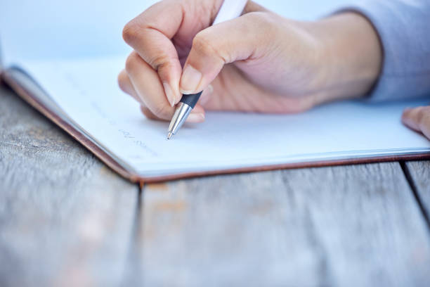 istock Shot of an unrecognizable businessman writing notes in his book while sitting outside 1373422565