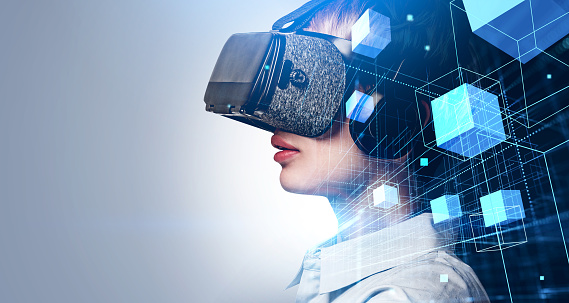 Businesswoman in white shirt is wearing vr helmet. Digital interface with geometrical figures, cubes and line connection in the foreground. Empty wall in the background. Concept of virtual reality