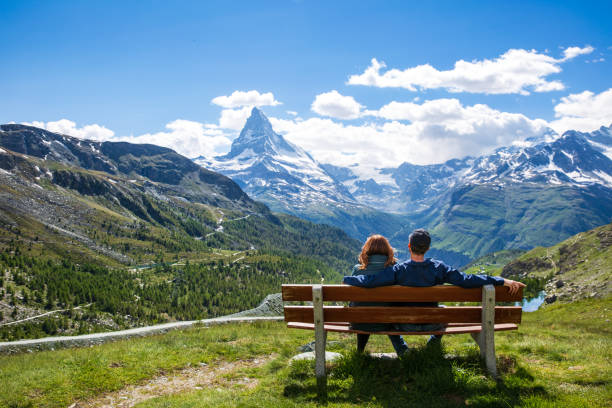 pareja en un banco contemplando la vista del matterhorn, zermatt suiza - matterhorn swiss culture european alps mountain fotografías e imágenes de stock