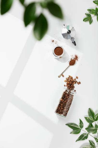 istock Coffee composition on light grey background, window shadow and green branches, flat lay, top view 1373462226