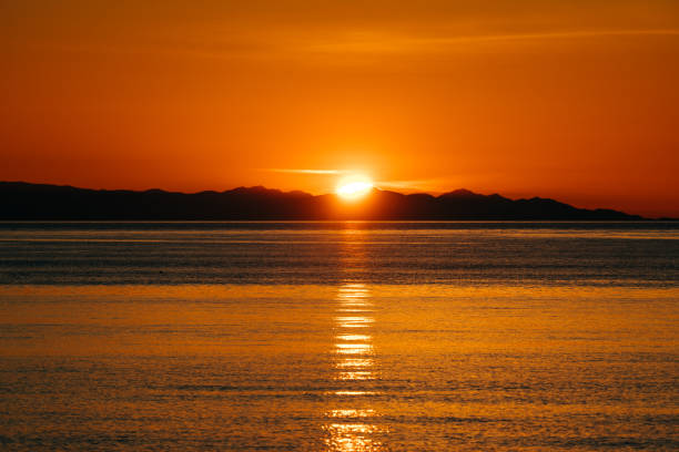 Distant view of the sunset over the Olympic Mountains in United States, Washington, Oak Harbor