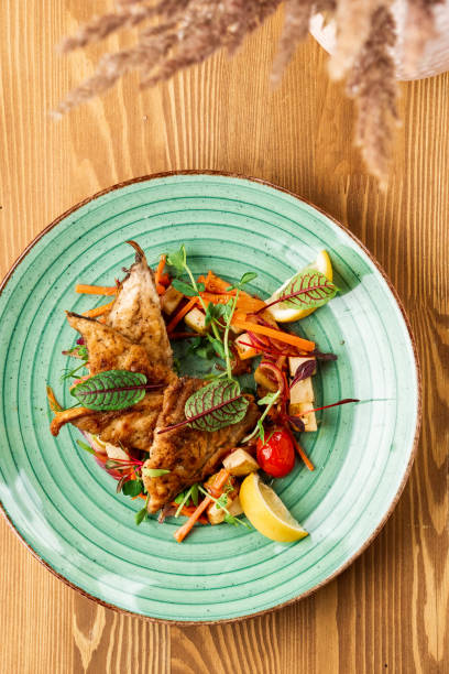 istock grilled fish with a side dish on a wooden background. Restaurant 1373464491