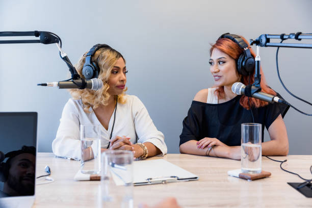 Female co-hosts record radio show in studio