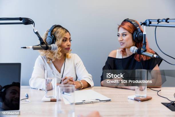 Female co-hosts record radio show in studio