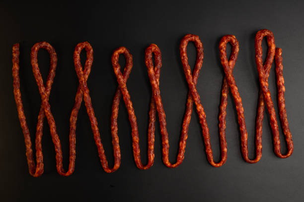 istock Cabanossi, dry sausage isolated on black background. 1373475184