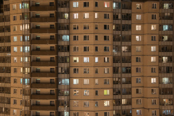 illuminated windows of an apartment building stock photo