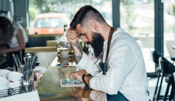istock Worried Barista Using Digital Tablet in a Cafe 1373505413