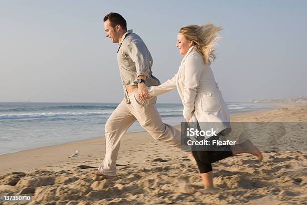 Happy Couple Running On Beach Stock Photo - Download Image Now - Adult, Beach, Couple - Relationship