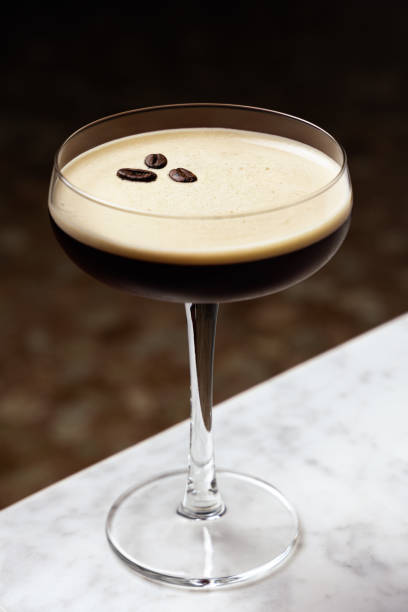 Espresso Martini garnished with three coffee beans, on a marble table Espresso Martini garnished with three coffee beans, on a marble table martini stock pictures, royalty-free photos & images
