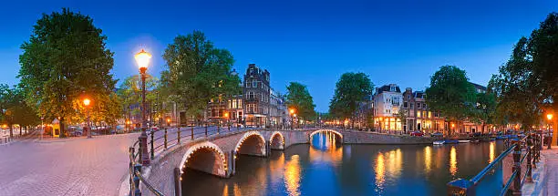 Pretty dutch doll houses illuminated and reflected along the tranquil canals of Amsterdam.