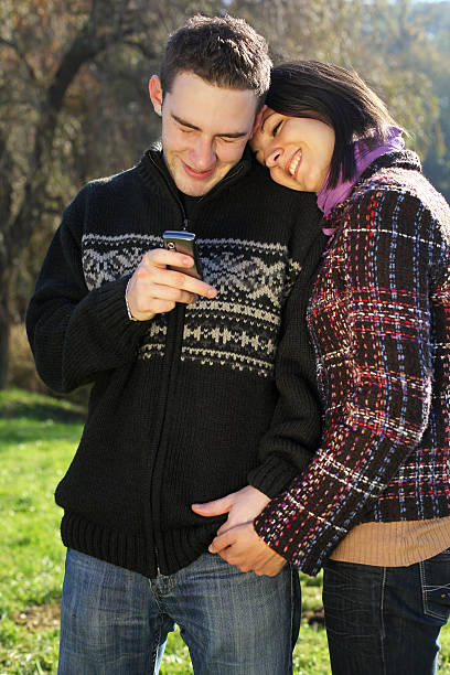 jeune couple en plein air avec téléphone mobile - adolescene photos et images de collection