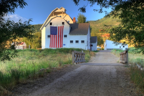 A huge american flag on a white barn in Park City Utah.