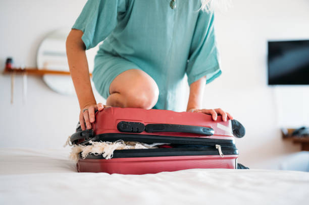 istock A woman has a problem with closing the suitcase 1373559843