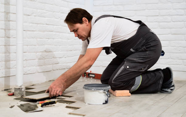 istock Installing ceramic floor tiles in construction site construction worker. Worker laying tiles on the floor with cement adhesive. Renovating the floor. 1373562788
