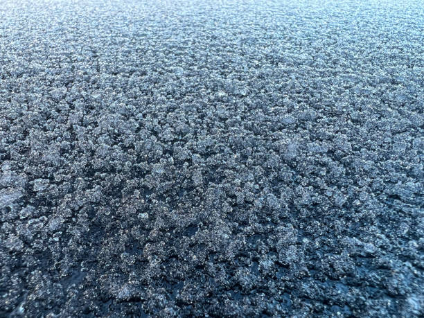 Melting ice on a painted black metal.