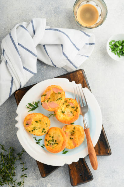 istock Egg muffins with green onions, bacon, cheese and tomatoes on white plate on light background. Healthy high protein and low carb breakfast, ready to eat. 1373576059