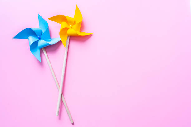 istock Two colored pinwheels on pink background. Copy space 1373584429