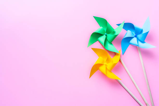 istock Colored pinwheels on pink background. Copy space 1373584435