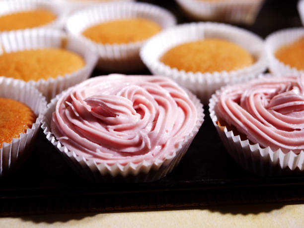 Home baked cupcake decorated with pink frosting close up shot selective focus