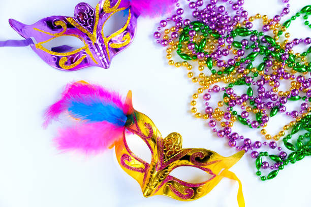 istock Two carnival masks with feathers and multi-colored beads on white background. Mardi Gras or Fat Tuesday symbol. 1373595388