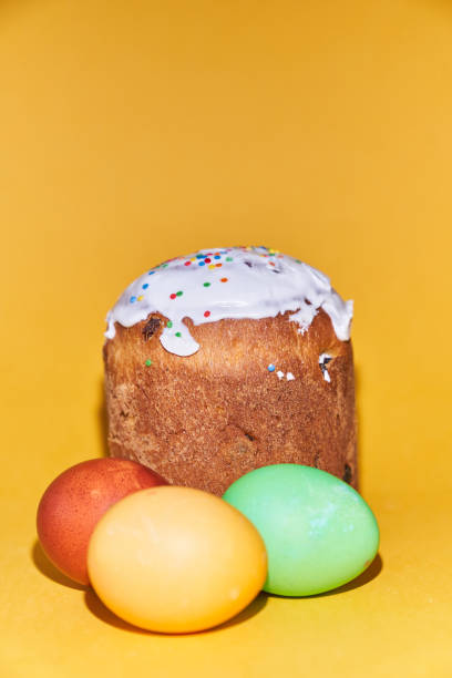istock Close-up of colored Easter eggs and kulich on a yellow background. With a space to copy 1373608002