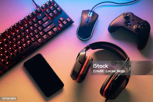 Gamer Work Space Concept Gaming Set Up Top View Of A Gaming Gear Keyboard Mouse Gamepad Joystick Headset And A Smartphone On A Colorful Desk Stock Photo - Download Image Now